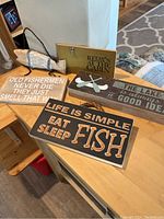 Four rustic decor signs on table and floor showing texts and themes