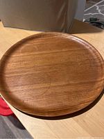 Top view of round wooden tray showing smooth wood grain surface and raised edges