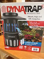 Box of Dynatrap Mosquito Trap showing product branding, coverage info, and bonus UV bulbs.