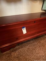 Closed view of cedar chest showing wood finish and keyhole on front.