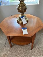 Top view of octagon wooden table showing wood grain and slight surface scratches. Metal lamp base on top is not included.