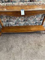 Full view of the wood sofa console table showing bottom shelf and legs.