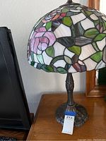 Full view of vintage stained glass lamp showing the dome-shaped shade and metal base.