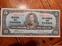 Front full view of the 1937 Bank of Canada five dollar bill showing portrait of King George VI and bilingual text.