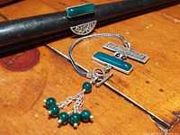 Photo of the 925 silver bracelet laying flat, showing rectangular jade inserts, toggle clasp, and dangling jade bead charms