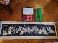 Overview of calligraphy set including ink stone, brushes, seal, and part of the scroll art