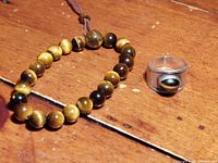 Photo showing the Tiger's Eye bracelet and sterling silver ring with Tiger's Eye stone resting on a wooden surface.