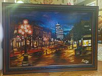 Frontal image of the oil painting showing the Gastown neighborhood in Vancouver at night with glowing street lamps and the Vancouver Lookout tower. Shows the scrolled dark wood frame and signature 'Rezia 2011' in the lower right.