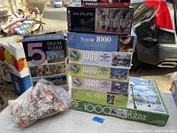 Photo showing all puzzles stacked including boxed and loose pieces, visible puzzle brand details and images.