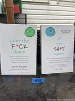 Photo of two Sarah Knight books: 'Calm the F*ck Down' and 'Get Your Sh*t Together' with white covers and color-coded circle labels on front. Both books appear in very good condition.