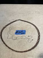 Two chains displayed on a flat surface, one twisted and gold plated sterling silver, the other a finer, thinner sterling silver chain.