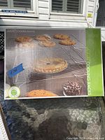 Photo of the boxed Fox Run Stainteel Cooling Racks showing cookies, a pie, and chocolate chips on the rack surfaces.