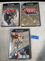 Overhead shot of three Nintendo GameCube game cases: Twilight Princess, The Wind Waker, Metroid Prime