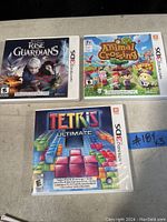 Photo of three Nintendo 3DS game cases: Rise of the Guardians, Animal Crossing, and Tetris Ultimate.