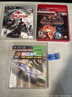 Photo showing three PS3 game cases: Dead Island, Mortal Kombat Komplete Edition Greatest Hits, and NASCAR The Game.