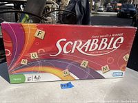 Box of Scrabble crossword game new in box, colorful with tile graphics, suitable for family ages 8+.