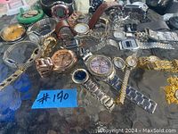 Top-down image showing a scattered assortment of analog and digital watches with various metal, leather, and silicone bands and different face styles and colors.