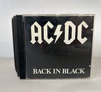 Front view of AC/DC Back in Black CD jewel case with black cover and white band logo text.