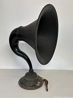 Front angled view of the antique horn speaker showing full curved horn, base, and attached cord.