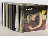 Side view of the CD collection showing 10 jewel case CDs with visible spines