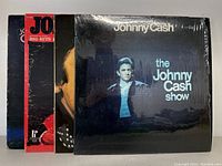 Four Johnny Cash vinyl records, including The Johnny Cash Show, Big Hits By The King of Country Volume 2, and more.