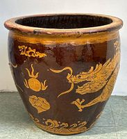 Full view of the large ceramic planter showing dragon and cloud designs on a brown glazed surface