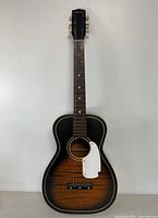 Full view of the guitar showing sunburst finish and white pickguard