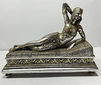 Overall front view of Cleopatra reclining sculpture on ornate base showing full figure and decorative details.