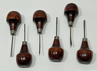 Top view of six palm handle wood carving tools showing blade shapes and wooden handles.