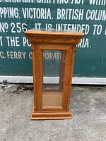 Front view of oak display case showing wood grain and glass panels