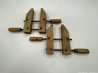 Two vintage Jorgensen wood clamps side by side showing wooden jaws and handles, metal threaded bars.