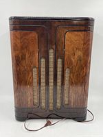 Front view showing the wood cabinet with Art Deco vertical grille design