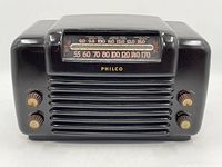 Front view of vintage black Philco tabletop radio showing tuning dial and four control knobs.