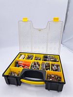 Full view of open yellow Stanley plastic carry case filled with multiple compartments containing various vintage vacuum radio tubes, including loose tubes and boxed tubes.