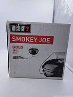 Front of the original box showing Weber branding and model name 'Smokey Joe Gold' with grill illustration.