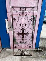 Full view of the rectangular wrought iron decorative panel showing scrollwork and central cross design.