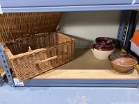 Wicker basket on shelf next to two ceramic pots