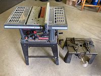Photo of Craftsman table saw and router table with collapsible plastic saw horses on the floor.