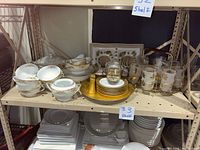 Full view of vintage china pieces showing double handled teacups, saucers, creamer, gravy boat, casserole dish, vegetable bowl, and gold-tone salt and pepper shakers.