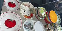 Overview of various bowls and plates including items with tomato print, vegetable designs, stacked colorful bowls, and solid red dishes.