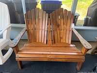Front view of wooden Adirondack double bench showing full structure and two-seat layout
