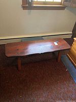 Top view of the wooden bench showing the natural wood grain, scratches, and overall condition.
