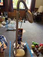 Full view of the 46-inch tall floor lamp with flexible arm and attached lamp head, shown in a room with other household items.