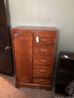 Front view of the wooden wardrobe dresser showing cabinet door and five drawers.