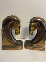 Front-facing view of both horse head bookends on white surface showing profiles, bases, finish and overall design.