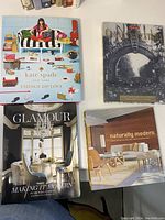Pile of four coffee table books showing front covers: 'Kate Spade: Things We Love,' 'MacLean's Canada's Century,' 'Metropolitan Home Glamour: Making it Modern,' and 'Naturally Modern.'