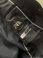 Close-up image of the interior label of the jacket showing the Zara brand and fabric details.