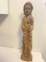 Full frontal view of carved statue showing mother holding child