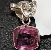 Front view of pendant showing heart-shaped bail and cushion-cut pink sapphire