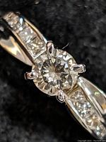 Close-up of round brilliant center diamond and adjacent channel-set side stones